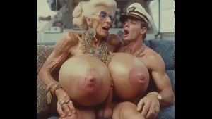 JAY7 Granny Boob Cruise 01 – AI VIDEO – A topless and horny granny with huge bolt-on tits gives a crazy titjob to the skipper