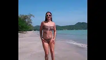 Sexy dancing in tight bikini on white sand beach