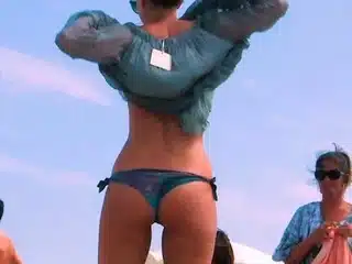 Playful nude beach girl caught on camera tanning